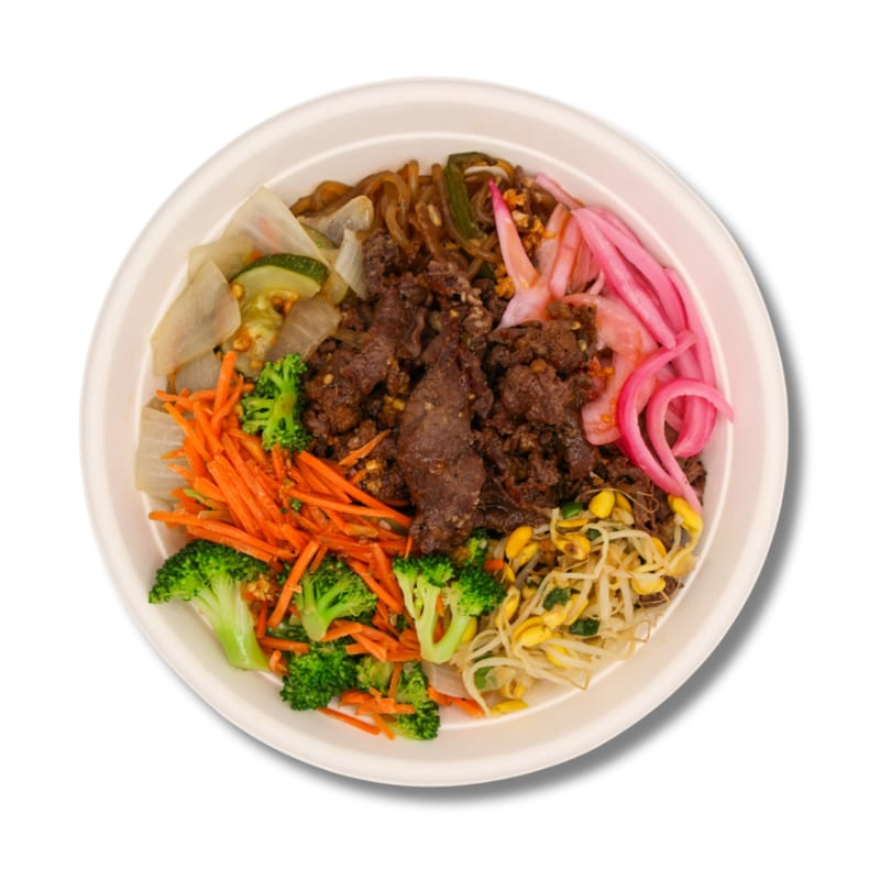 Colorful bowl with beef, broccoli, carrots, pickled onions, bean sprouts, and noodles.
